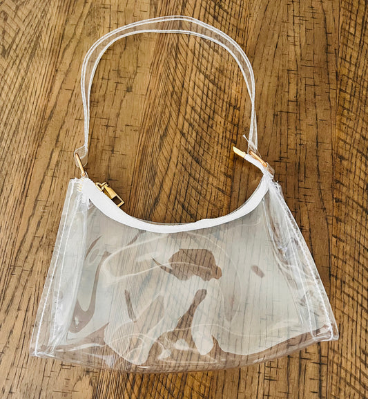 Clear purse with white trim and gold accents